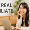 明るい室内でノートパソコンを操作しながら笑顔を見せる今どきの主婦。白とウッド調のインテリアに囲まれたナチュラルな空間でアフィリエイト作業中。
